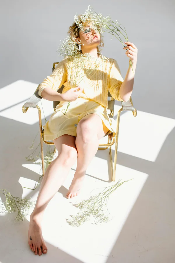 Femme artistique entourée de fleurs sous lumière naturelle