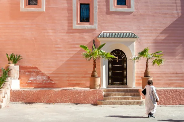 Architecture marocaine rose avec palmiers et entrée traditionnelle