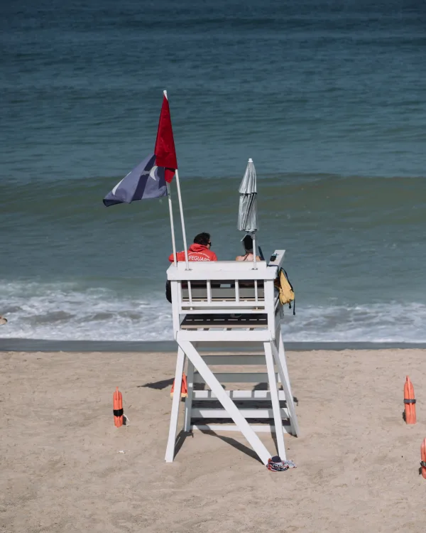 Poste de secours sur une plage avec sauveteur et drapeaux de sécurité