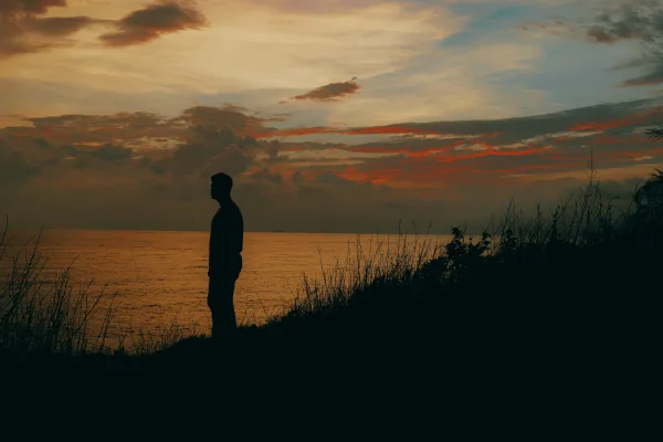 Silhouette d’un homme face au coucher de soleil sur la mer