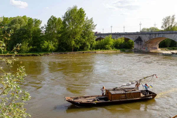 Bateau traditionnel sur une rivière près d’un vieux pont