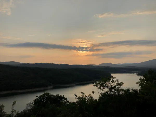 Coucher de soleil sur un lac entouré de collines