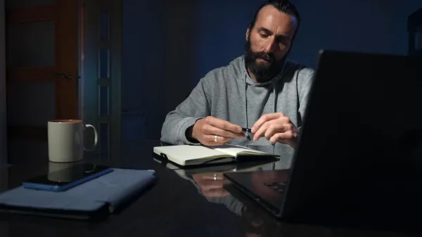 Homme travaillant tard le soir sur ordinateur portable à domicile