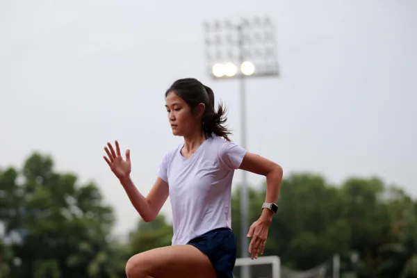 Jeune femme courant sur une piste d’athlétisme en plein entraînement