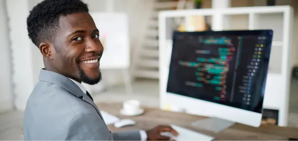 Développeur informatique souriant travaillant sur un projet de code