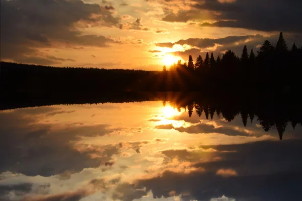Coucher de soleil spectaculaire sur un lac avec reflet parfait