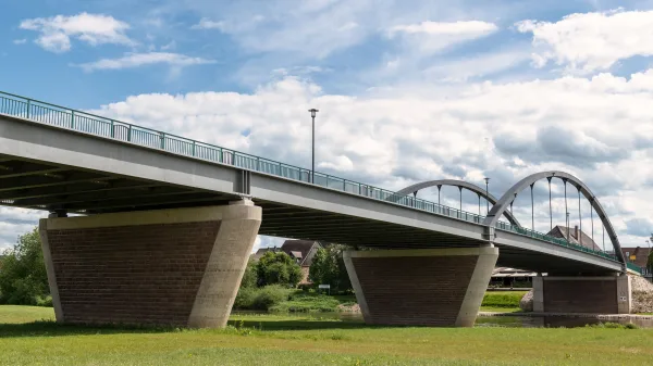 Pont moderne traversant une rivière sous un ciel nuageux