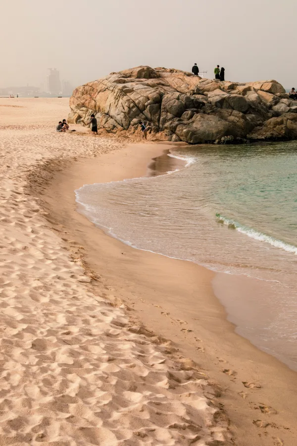 Plage de sable fin avec formations rocheuses au bord de la mer