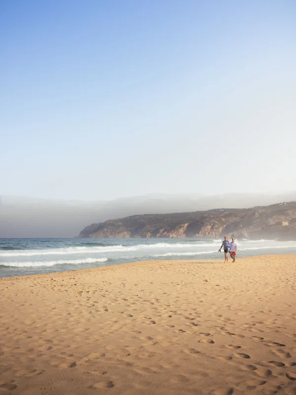 Plage de sable doré avec vue sur l'océan et les falaises