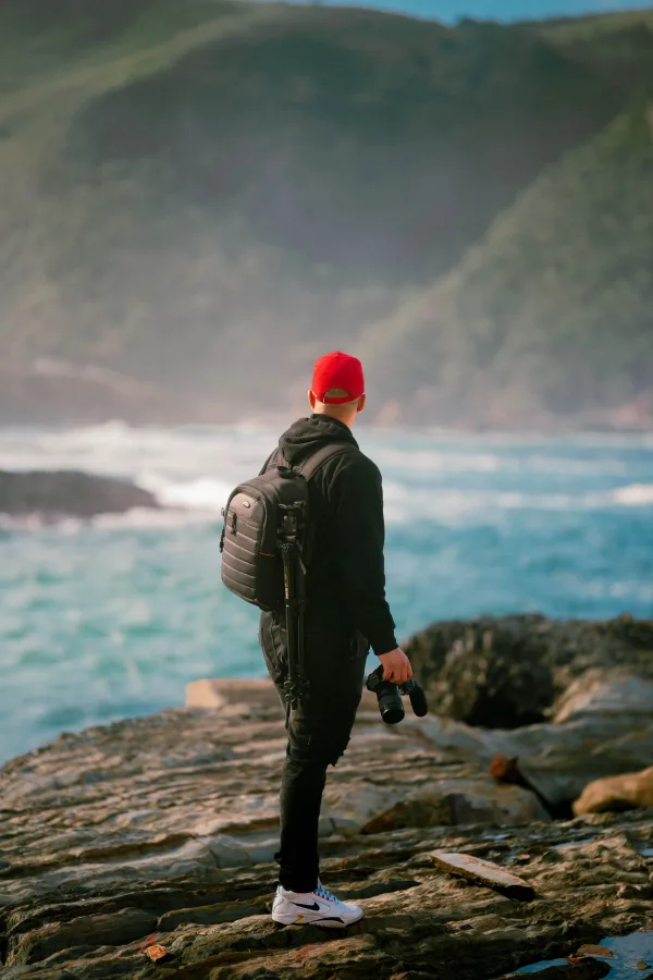 Photographe explorant une côte sauvage face à l'océan
