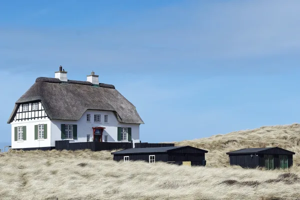 Maison traditionnelle au toit de chaume dans les dunes côtières