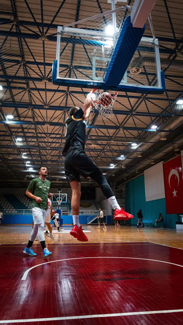 Joueur de basketball réalisant un dunk lors d’un match en salle