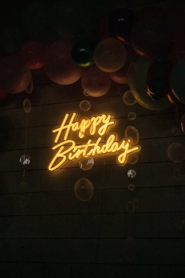Enseigne lumineuse Happy Birthday avec ballons dans une ambiance festive