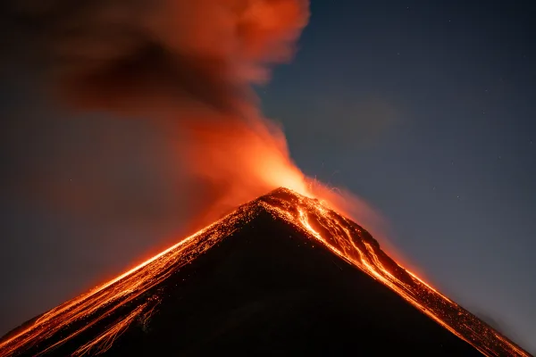 Volcan en éruption de nuit avec coulées de lave incandescentes