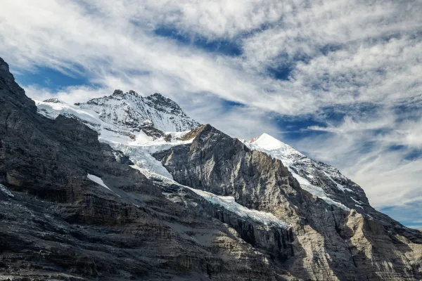 Montagnes enneigées et glacier sous un ciel nuageux