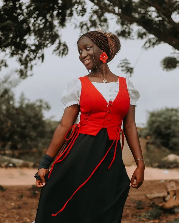 Portrait d'une jeune femme souriante en tenue traditionnelle rouge et noire
