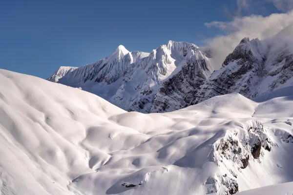Paysage de montagnes enneigées sous un ciel bleu en hiver