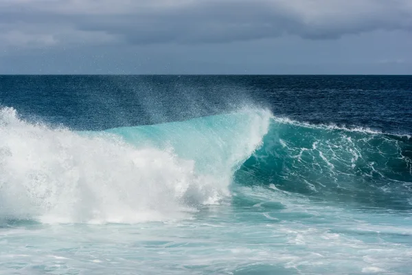 Vague puissante dans l’océan des îles Galápagos sous un ciel orageux