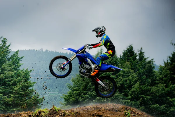 Pilote de motocross réalisant un saut spectaculaire en pleine nature
