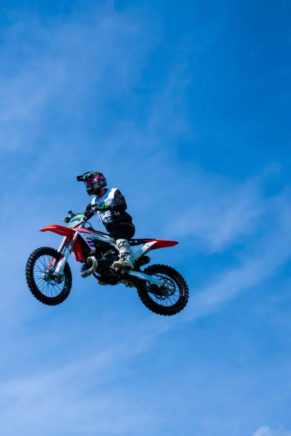 Motocross aérien : pilote réalisant un saut spectaculaire dans le ciel
