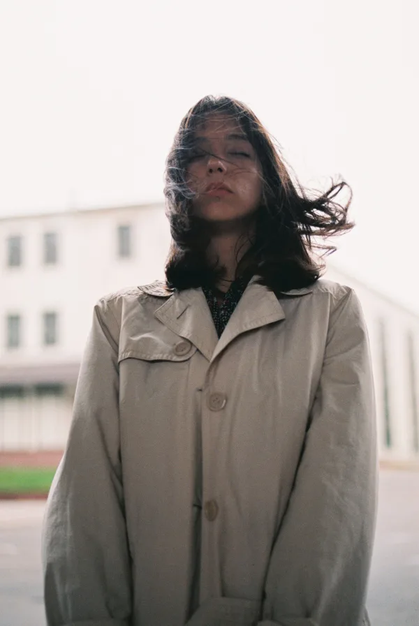 Portrait artistique d’une jeune femme au manteau dans un décor urbain