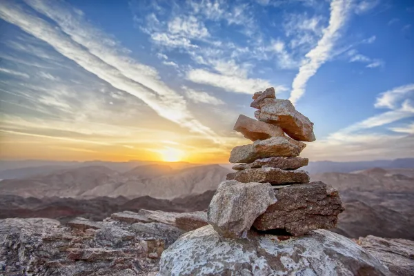 Cairn en pierres au coucher du soleil dans un paysage de montagne