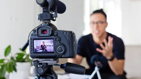 Créateur de contenu enregistrant une vidéo avec caméra et microphone professionnel
