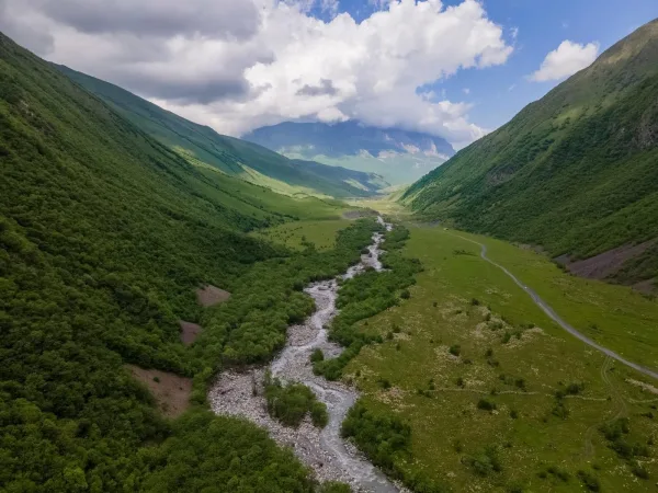 Vallée verdoyante traversée par une rivière au cœur des montagnes