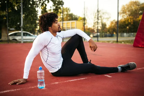 Sportif en récupération après un entraînement sur une piste d'athlétisme