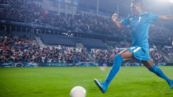 Footballeur frappant le ballon lors d'un match dans un stade