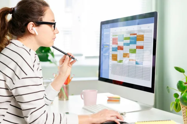 Femme organisant son planning de travail sur un calendrier numérique
