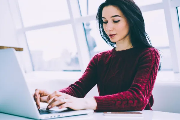 Jeune femme travaillant sur un ordinateur portable dans un bureau moderne