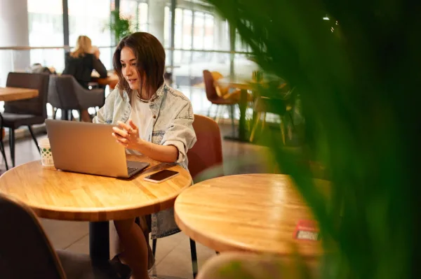 Jeune femme freelance travaillant sur son ordinateur portable dans un café moderne