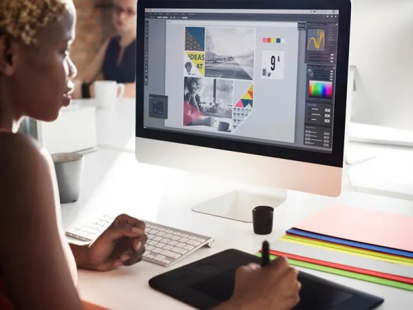 Graphiste professionnel créant un design graphique sur ordinateur avec tablette graphique