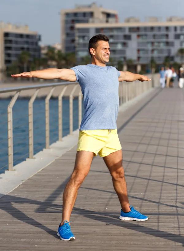 Homme faisant des étirements en plein air avant une séance de sport, symbole de discipline, de santé et de bien-être