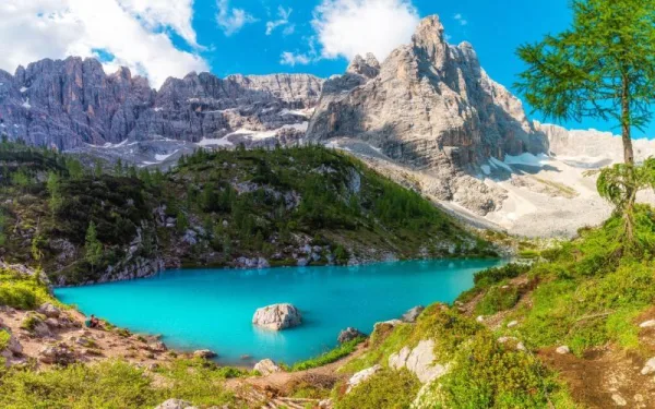 Lac de montagne turquoise entouré de sommets rocheux majestueux