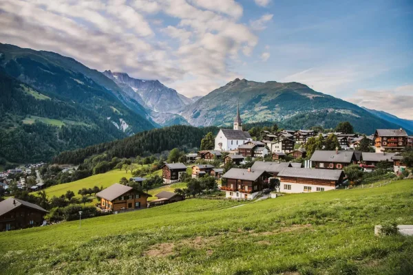 Village alpin pittoresque entouré de montagnes et de prairies verdoyantes