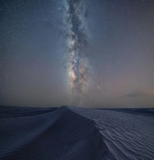 Voie lactée au-dessus des dunes du désert sous un ciel nocturne étoilé
