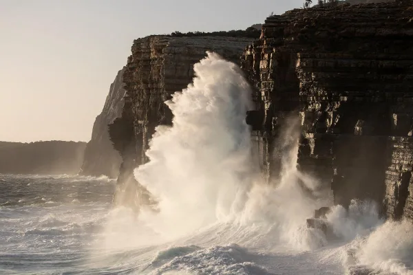 Vagues géantes s'écrasant contre des falaises rocheuses au bord de l'océan