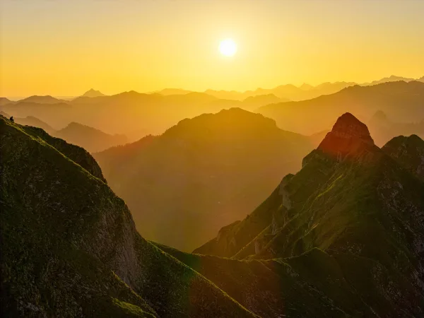 Coucher de soleil sur une chaîne de montagnes aux sommets majestueux