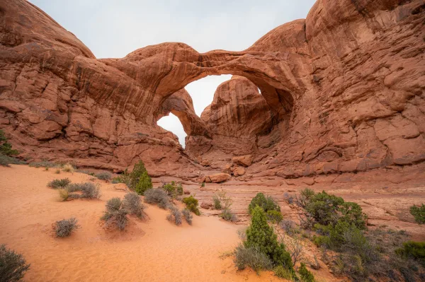 Double arche naturelle de roche rouge dans un paysage désertique