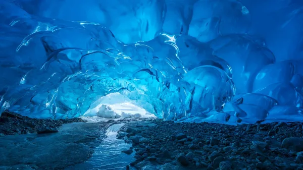 Grotte de glace bleue avec rivière glaciaire en paysage polaire