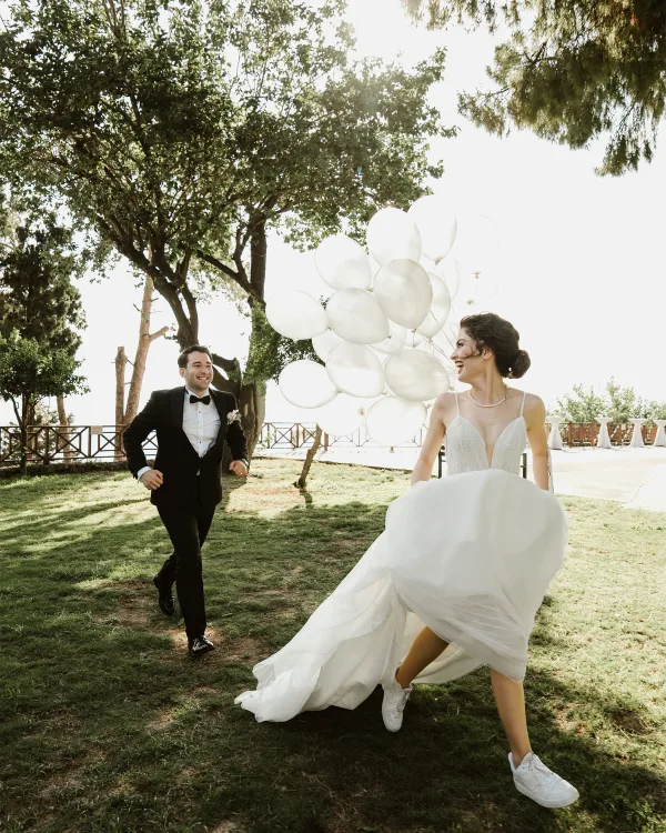 Jeunes mariés courant dans un jardin lors d'une cérémonie de mariage en plein air