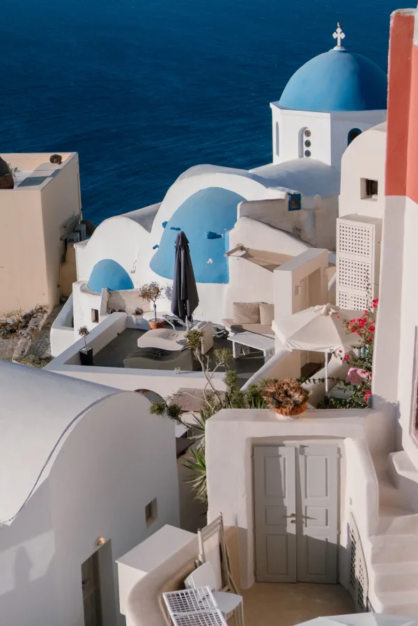 Village blanc aux dômes bleus surplombant la mer en Grèce