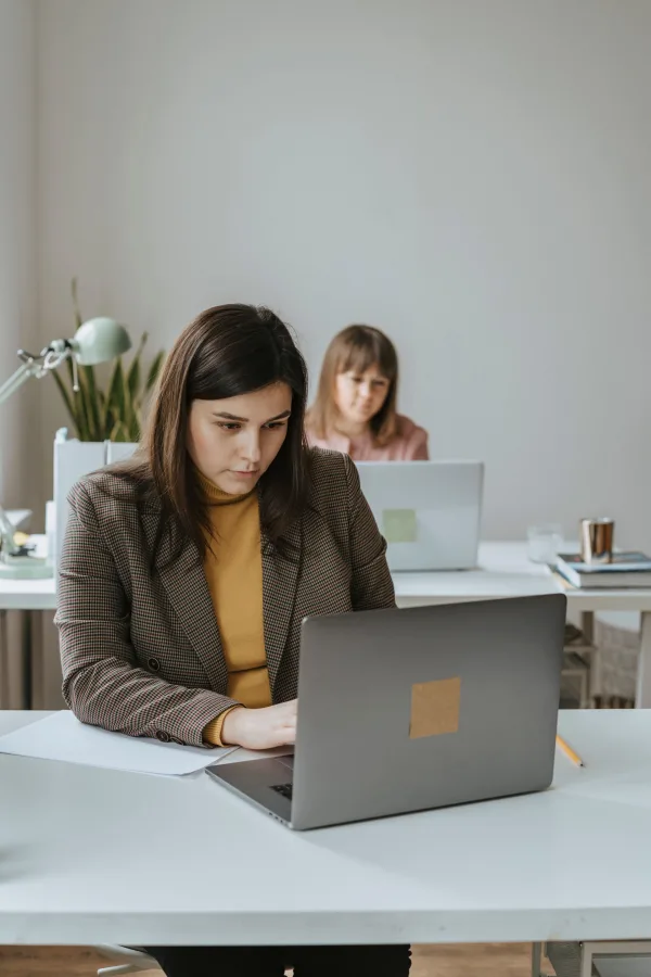 Femmes professionnelles travaillant sur ordinateur dans un bureau collaboratif moderne