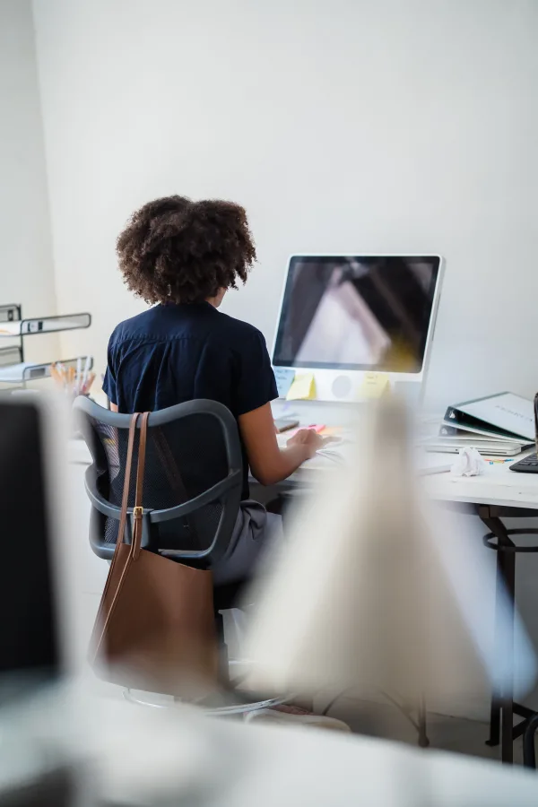 Employée travaillant sur un ordinateur de bureau dans un espace de travail moderne